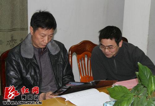 图为县委书记赵湘明(图左)在石门乡调研时检查群众工作资料