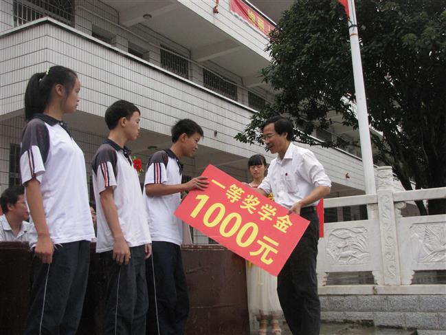 图为校长为获得一等奖学金的学生颁奖