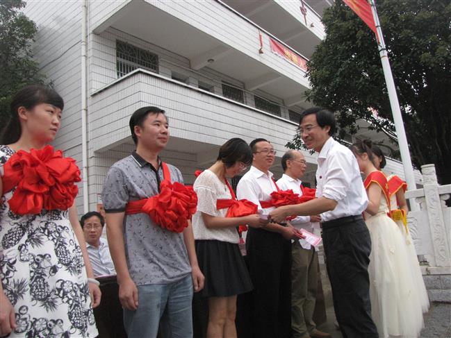 图为校长卢小军为获得示范班主任的老师颁奖